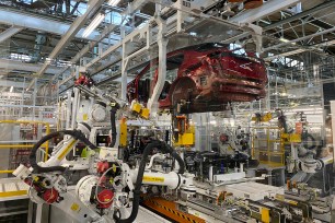 Robotic arms put in the electric vehicle powertrain into the Ariya model in the assembly line at Nissan's Tochigi plant in Kaminokawa town, Tochigi prefecture, Japan, Friday, Oct. 8, 2021.
