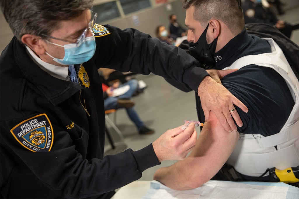 A member of the New York Police Department (NYPD) receives a dose of the Moderna Covid-19 vaccination