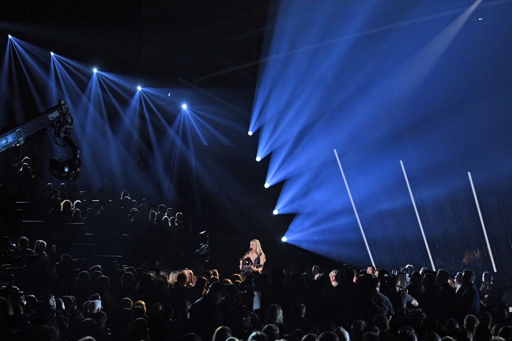 Carrie Underwood onstage in front of a large audience. 