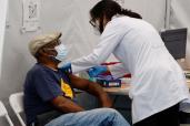 A man in the Bronx getting a COVID-19 vaccine shot. A poll found that New York City residents are more willing to get vaccinated than the rest of the country.