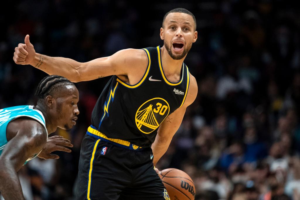 Golden State Warriors guard Stephen Curry (30) motions for a play while being defended by Charlotte Hornets guard Terry Rozier.