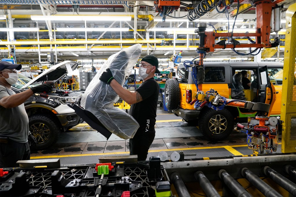 An assembly line worker works on a 2021 Ford Bronco on the line at Michigan Assembly Plant, Monday, June 14, 2021, in Wayne, Michigan.
