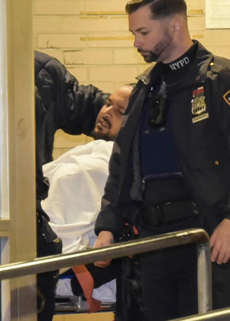Santiago, center, being wheeled into the hospital after his arrest.
