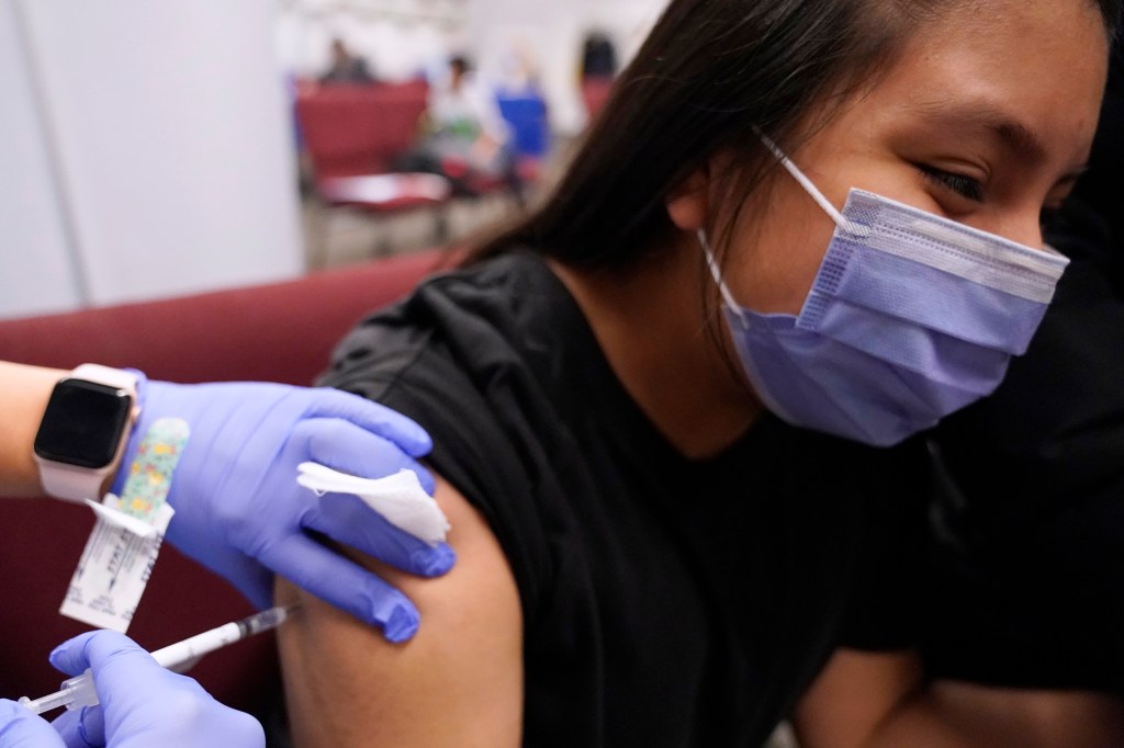 An 11-year-old receives her second dose of the Pfizer COVID-19 vaccine. 