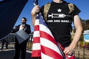 Protests organized, in part, by far-right, white nationalist political commentator Nicholas J. Fuentes, hold an American flag during a protest against Covid-19 vaccines and government vaccination mandates outside of Staten Island University Hospital in the borough of Staten Island in New York, New York, USA, 10 November 2021.