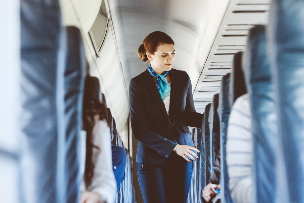 A flight attendant checks the aisles of the plane.