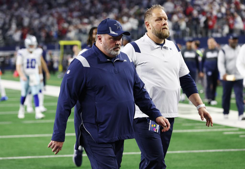 Mike McCarthy walks off the field.