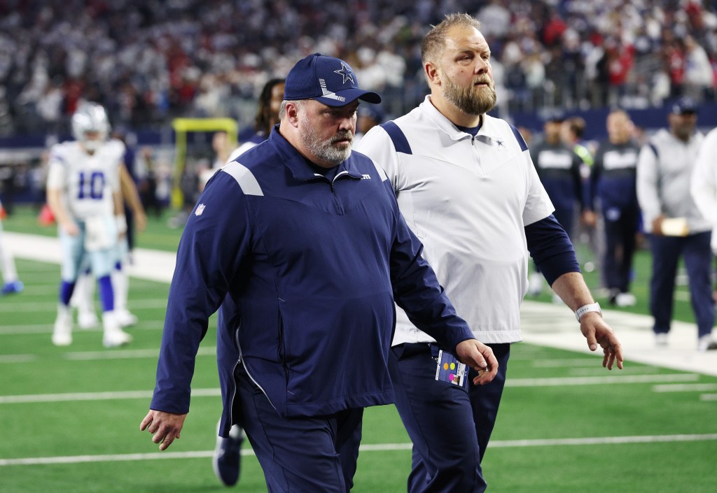 Mike McCarthy walks off the field. 