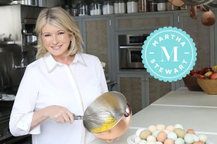 Martha Stewart whipping eggs in a bowl in an industrial kitchen