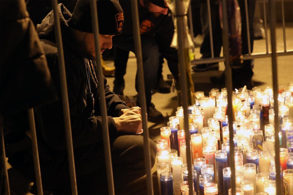 An officer lights a memorial candle at the vigil.