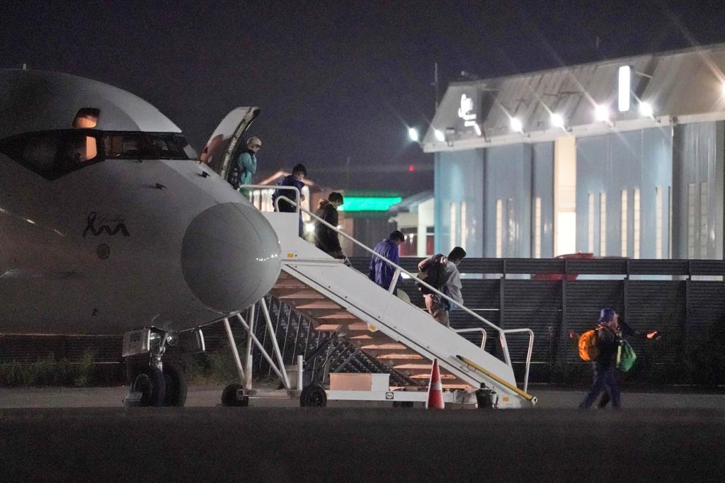 Immigrants from the southern border getting off a World Atlantic Airlines airplane and boarding charter buses at Westchester County Airport in White Plains, NY on October 15, 2021