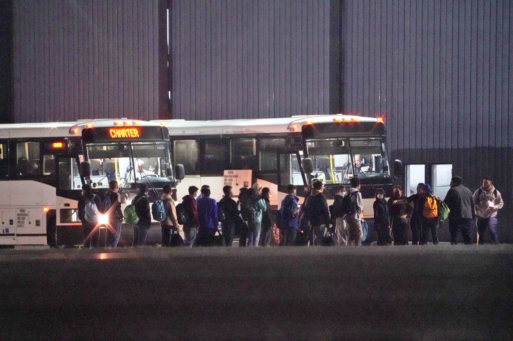 Immigrants from the southern border getting off a World Atlantic Airlines airplane and boarding charter buses at Westchester County Airport in White Plains, NY on October 15, 2021