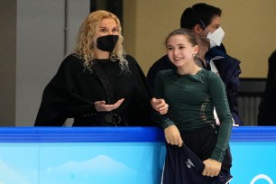 Russian Olympic Committee coach Eteri Tutberidze talks to figure skater Kamila Valieva during a practice session on Feb. 12, 2022.