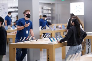 Apple retail worker speaking with customer