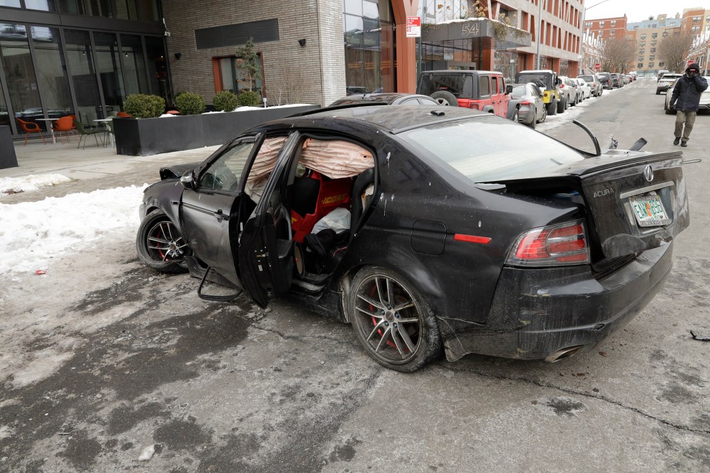 An Acura crashed into a black Audi, knocking the wheel off of the Audi.