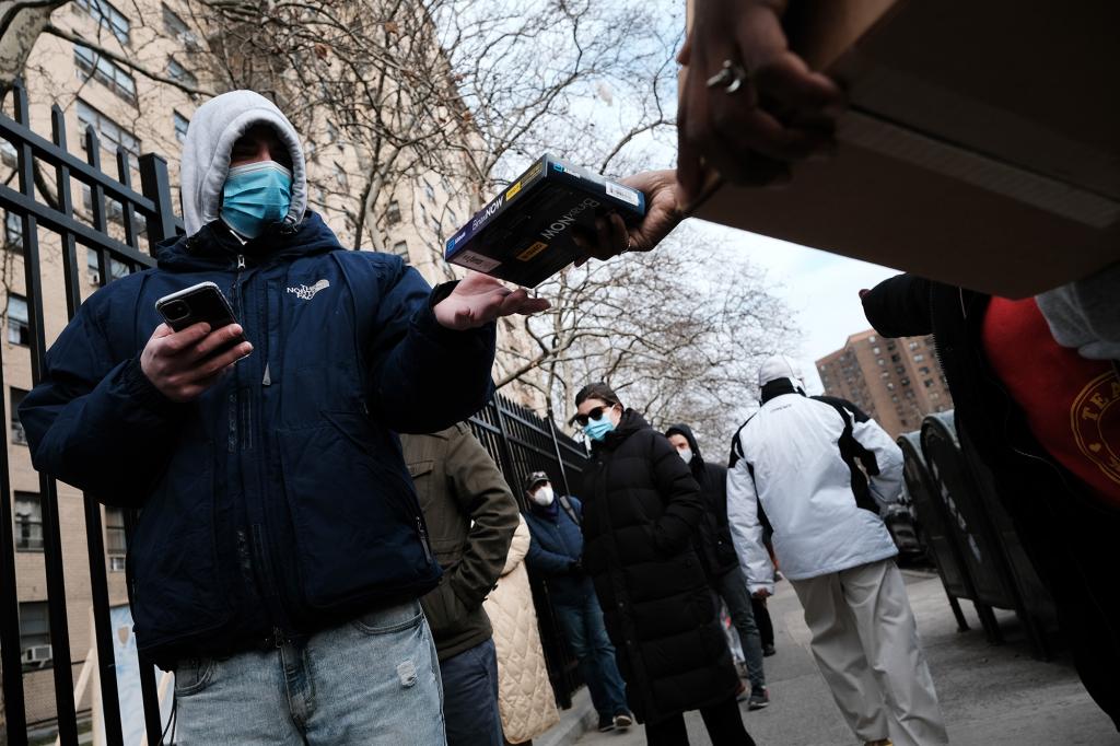 City workers hand out take-home Covid-19 test kits in lower Manhattan on December 23, 2021.