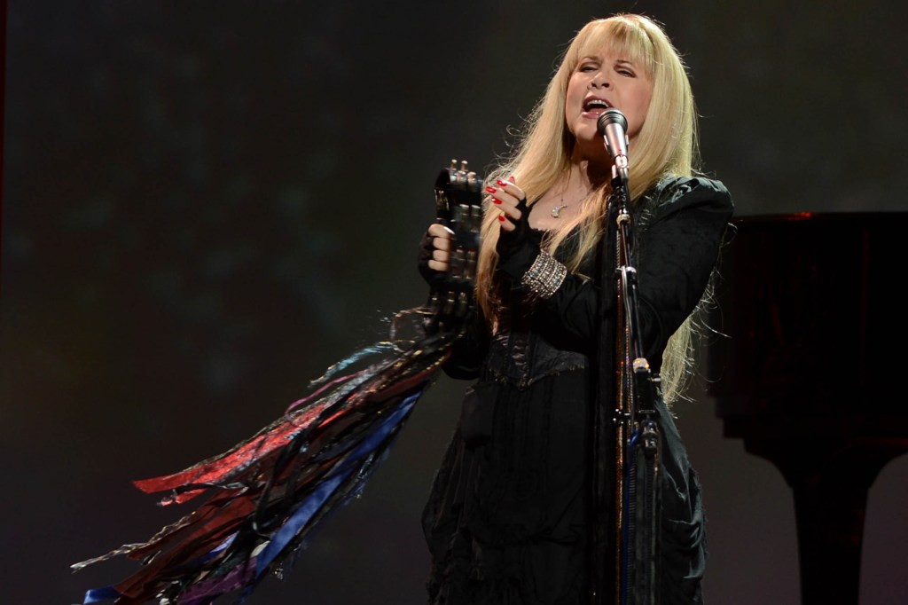 Stevie Nicks sings and plays tambourine on stage