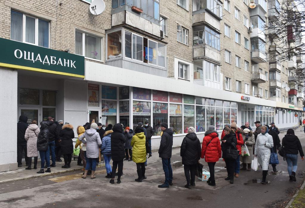 People queue to withdraw money at cash machines in the western Ukrainian city of Lviv.