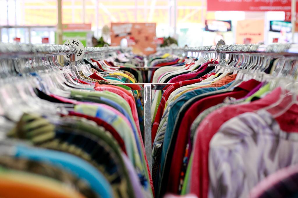 a variety of colorful shirts hang on a clothing rack at a thrift store