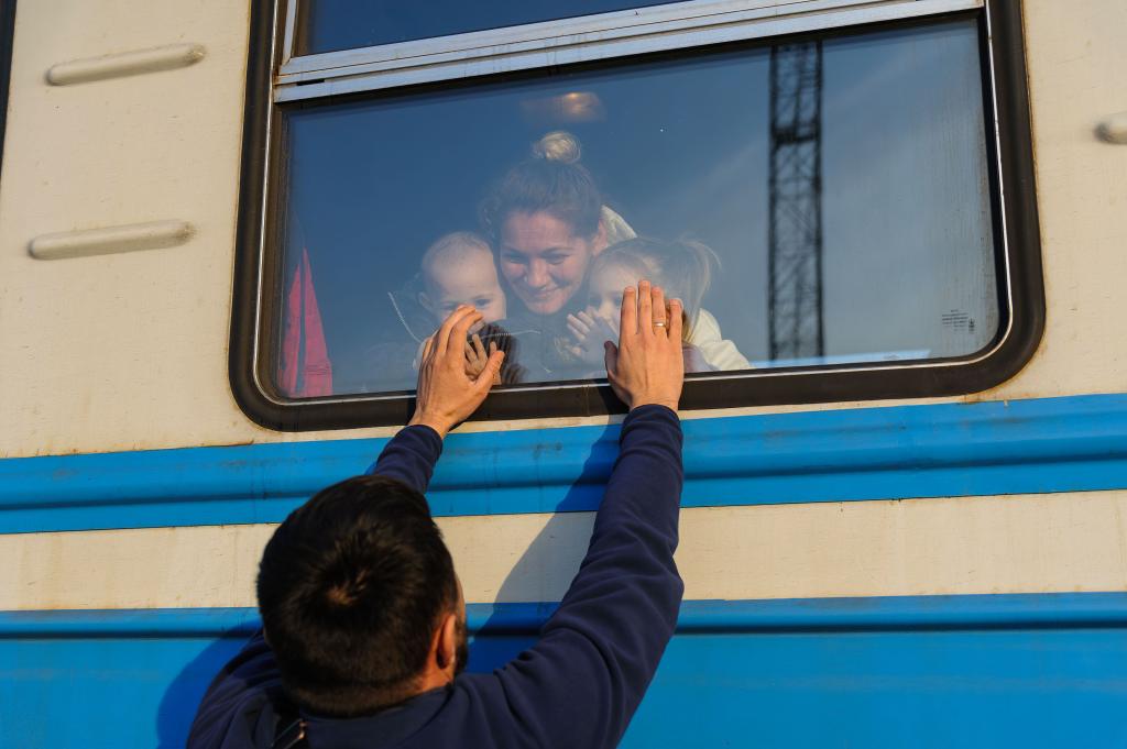 A man gestures to his family outside a train to Poland at Lviv Railway station amid Russian invasion to Ukraine.