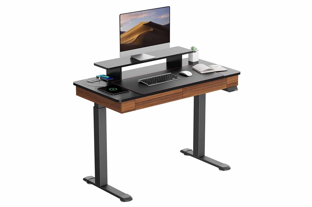 A brown standing desk with a computer on it 