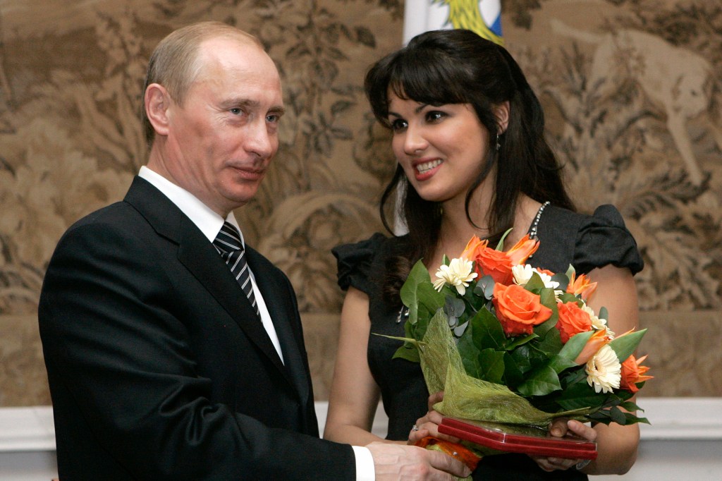 FILE - Russian President Vladimir Putin, left, congratulates Russian opera singer Anna Netrebko after awarding her with the People's Artist of Russia honor, during the 225th anniversary celebrations of the Mariinsky Theater in St. Petersburg, Russia, on Feb. 27, 2008. Netrekbo withdrew from her future engagement at the Metropolitan Opera rather than repudiate her support for Russia President Vladimir Putin, costing the company one of its top singers and best box-office draws. (AP Photo/Dmitry Lovetsky, File)