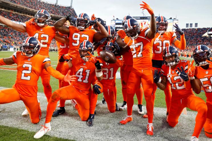 Justin Simmons #31 of the Denver Broncos celebrates an interception with teammates.