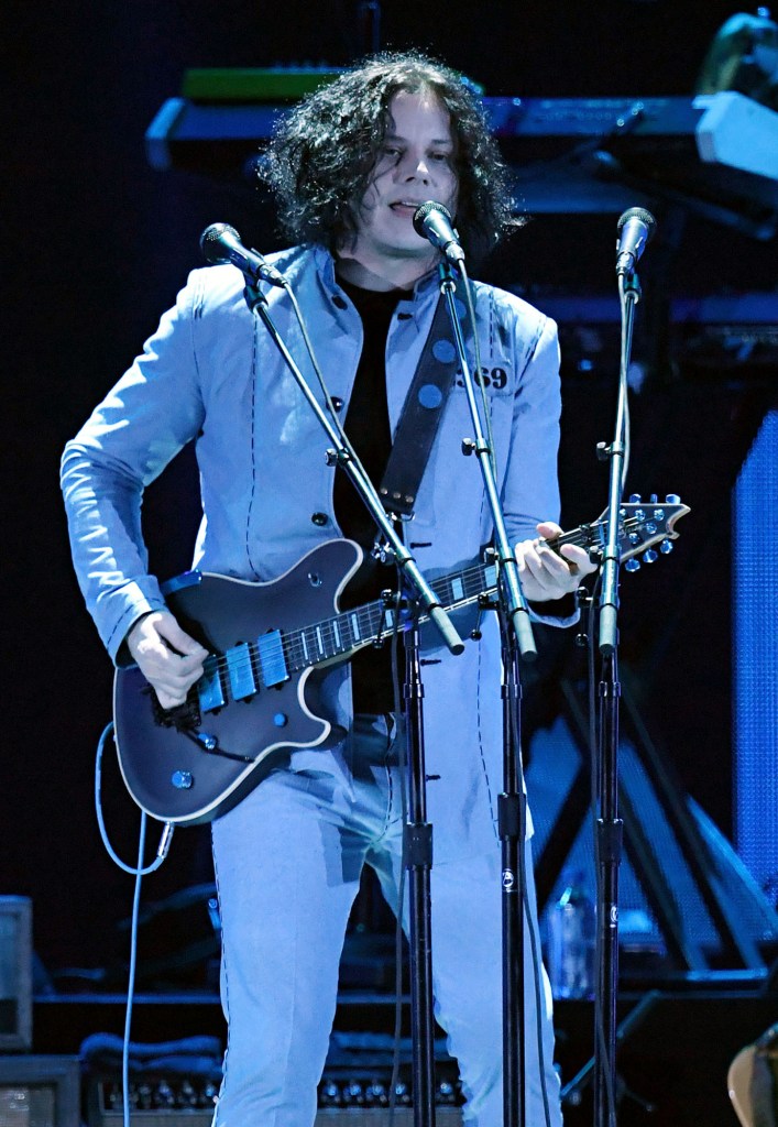 Jack White onstage under blue lights.