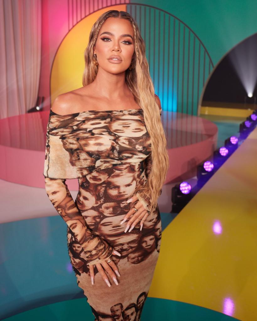 Khloe Kardhasian in a form fitting dress against a colorful set.