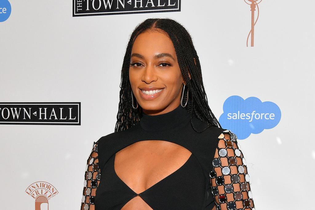 Solange Knowles smiles in a black cut out dress.