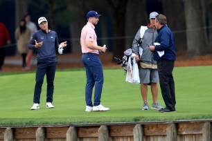 Daniel Berger (second from right) and Viktor Hovland discuss Berger's drop on the 16th hole.