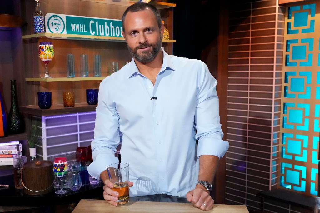 Evan Goldschneider in a blue shirt on the set of WWHL.