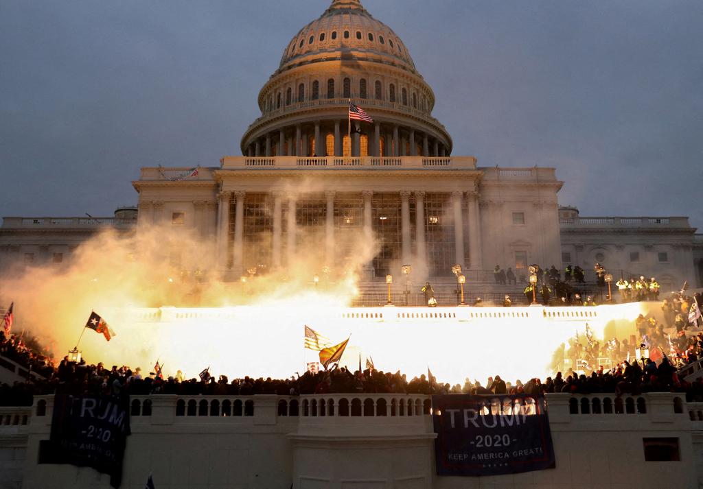 An explosion caused by a police munition is seen while supporters of U.S. President Donald Trump riot at the U.S. Capitol on January 6, 2022.