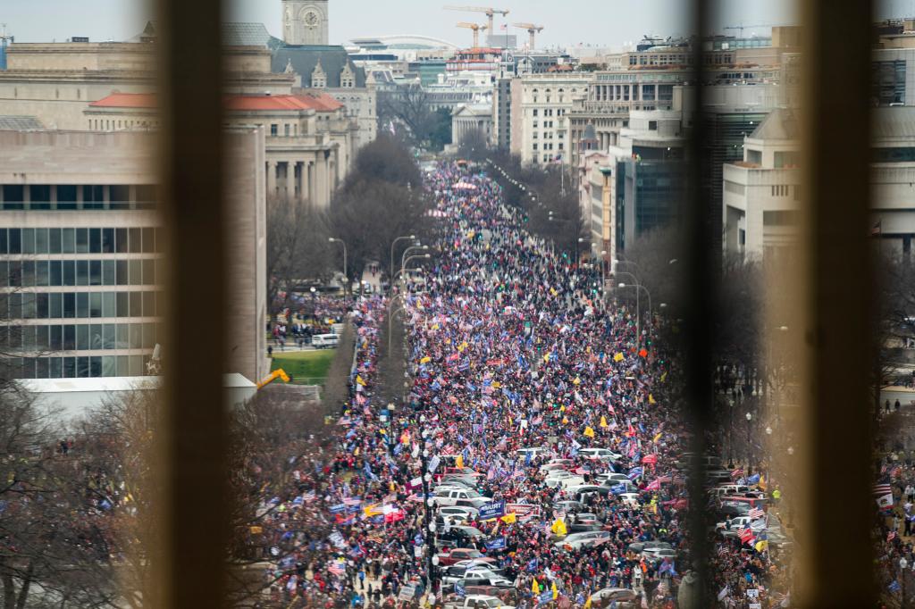 Supporters of former President Donald Trump march down Pennsylvania Avenue as they breach Capitol security and climb the inauguration stand to protest Congress certifying Joe Biden's presidency.