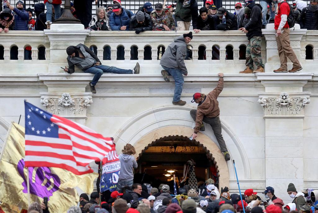 A mob of supporters of U.S. President Donald Trump fight with members of law enforcement at a door they broke open as they storm the U.S. Capitol Building in Washington, U.S., January 6, 2021.