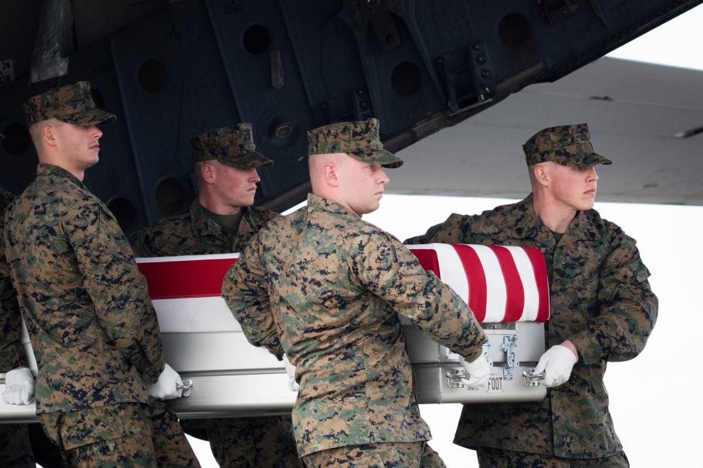 A U.S. Marine Corps carry team carries the transfer case containing the remains of Marine Capt. Matthew J. Tomkiewicz, of Allen, Indiana, during a dignified transfer at Dover Air Force Base March 25, 2022 in Dover, Delaware.