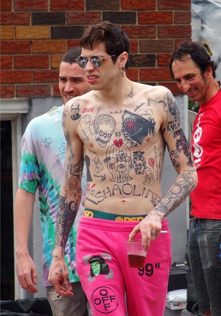 Pete Davidson walks shirtless in pink sweatpants.