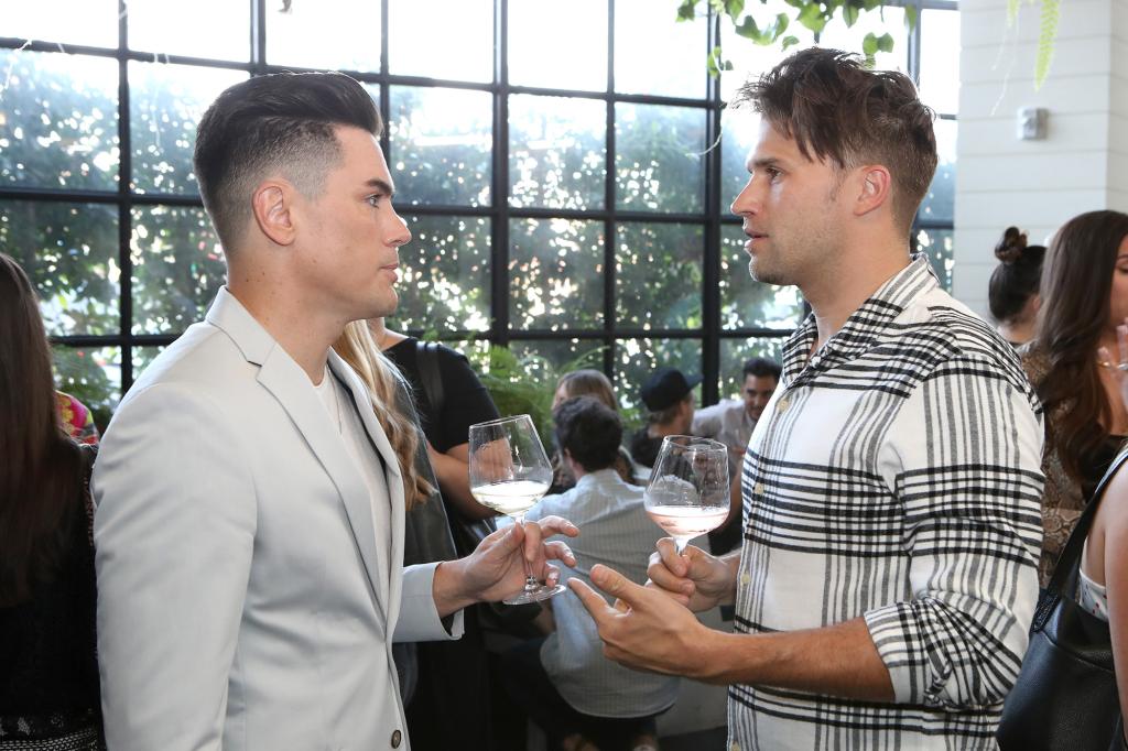 Tom Sandoval and Tom Schwartz stand opposite each other in conversation.