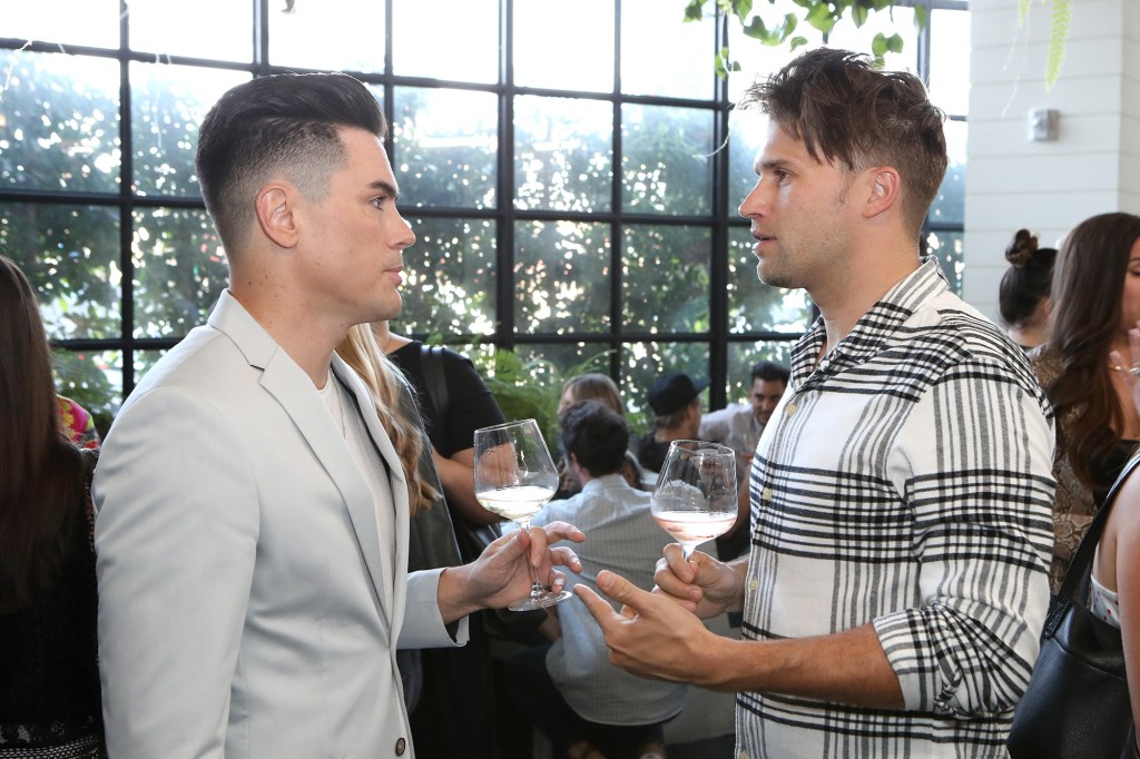 Tom Sandoval and Tom Schwartz stand opposite each other in conversation. 