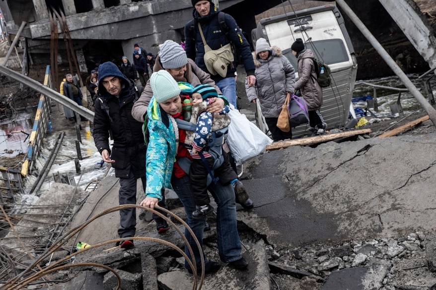 Residents of Irpin flee heavy fighting via a destroyed bridge as Russian forces entered the city on March 7.