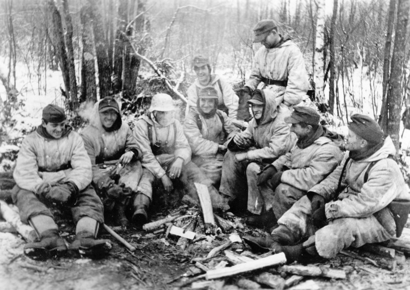 Soldiers keep warm near an open fire in the Pinsk Marshes, Feb. 1944.