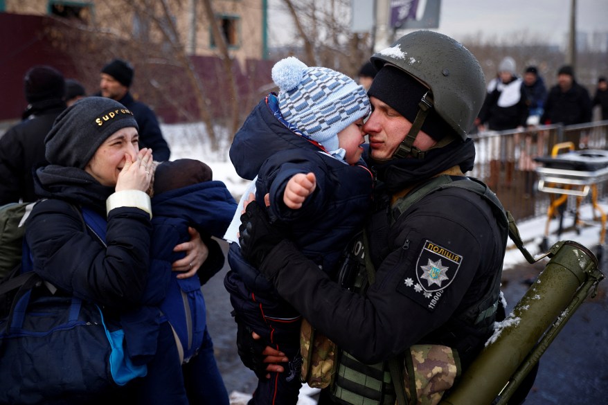 A police officer says goodbye to his son as his family flees from advancing Russian troops in the town of Irpin outside Kyiv, March 8.