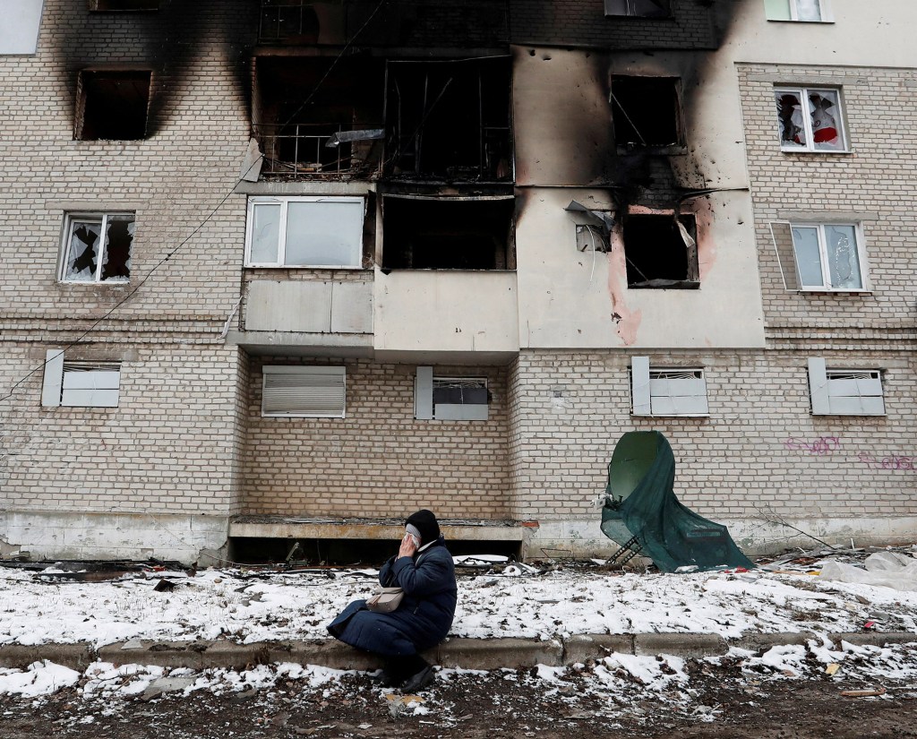 A woman reacts in front of a residential building which was damaged during Ukraine-Russia conflict in the separatist-controlled town of Volnovakha