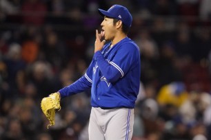 Blue Jays starting pitcher Yusei Kikuchi licks his finger while preparing to pitch during the first inning of a baseball game against the Boston Red Sox, Tuesday, April 19, 2022, at Fenway Park in Boston.
