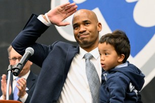 New Seton Hall coach Shaheen Holloway waves to the crowd as he holds his son Tyson during his introductory press conference.