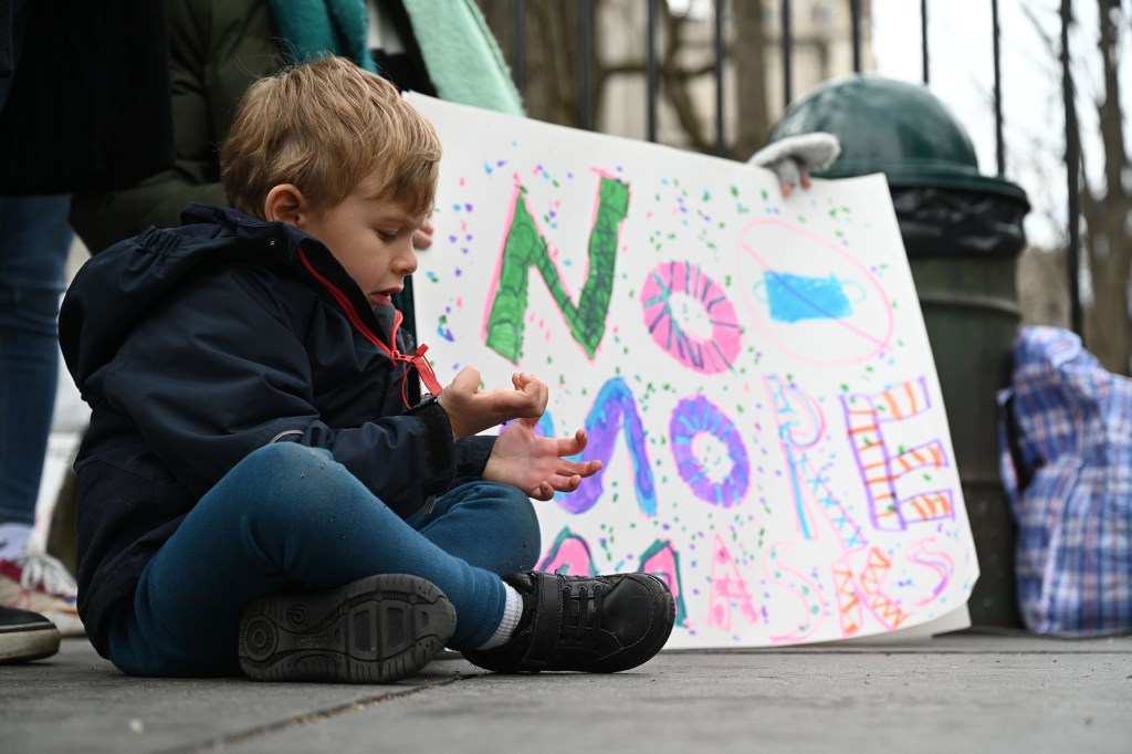 A toddler sits during a protest against mask mandates for school children on April 4.