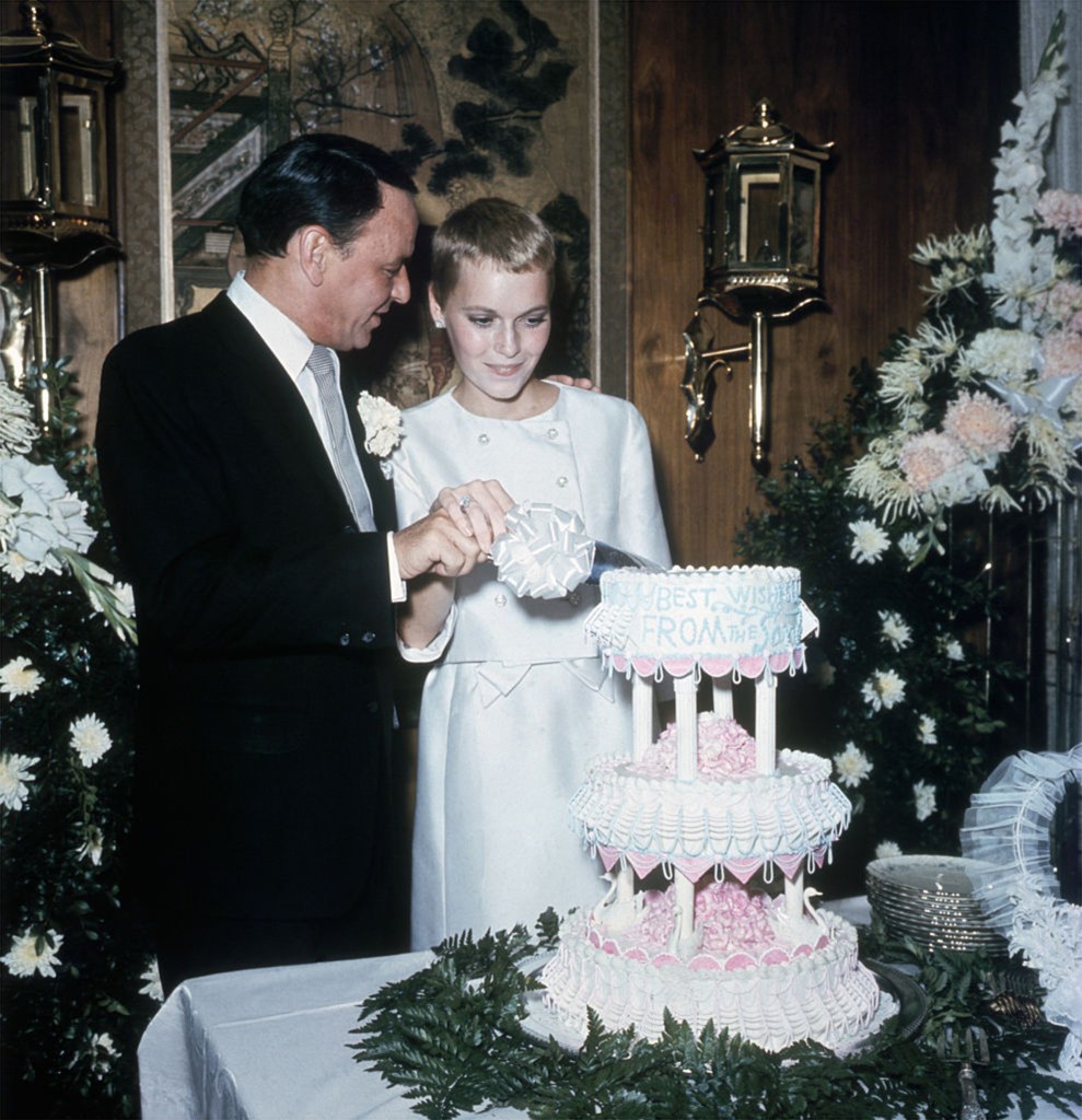 Frank Sinatra and Mia Farrow cut their wedding cake 