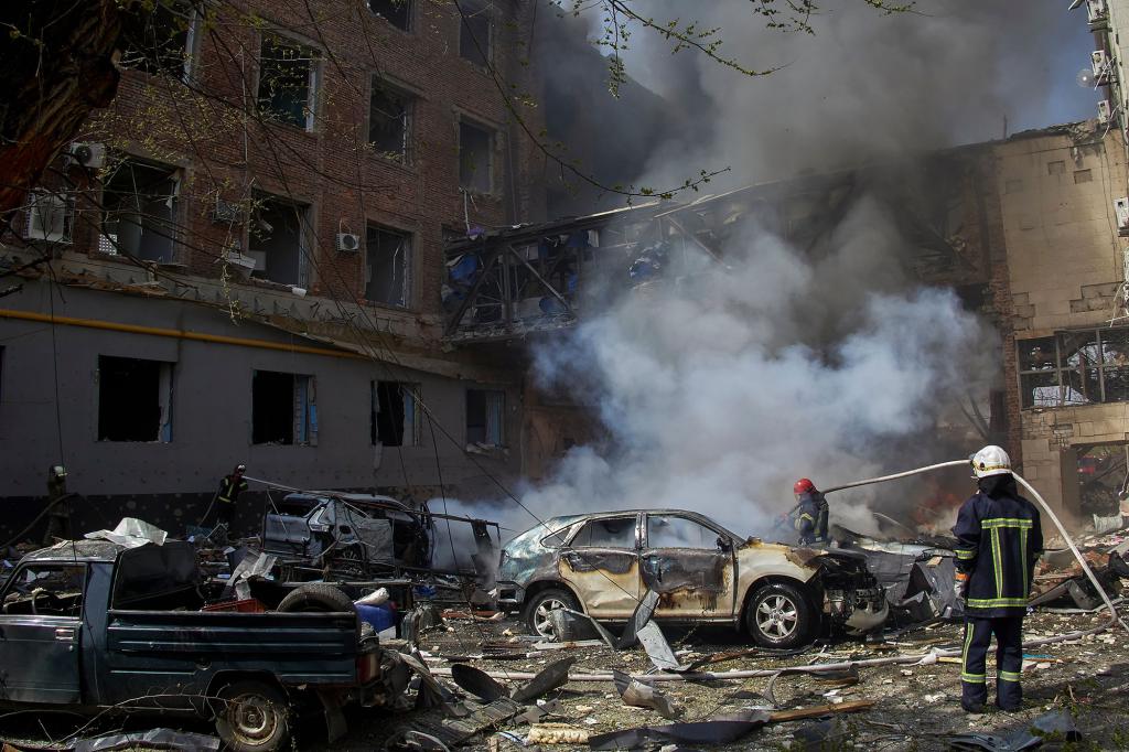 Ukrainian firefighters work at a damaged residential area following a Russian shelling.