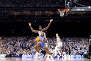 Armando Bacot drives to the rim in the March Madness national championship game