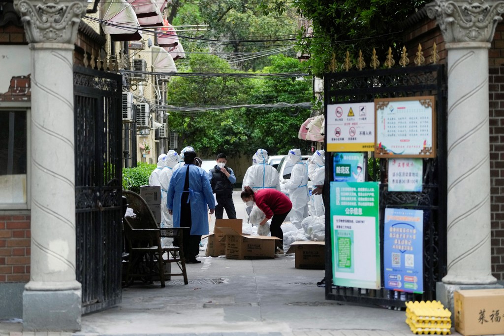 Workers in protective suits  are seen at a residential area under lockdown amid the coronavirus disease (COVID-19) pandemic, in Shanghai, China April 15, 2022. 